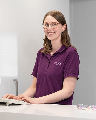 Angestellte Frau Voss am Computer beim Empfang der Praxis