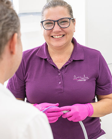 Assistenz-Angestellte Frau Förster mit einem Schlauch in den Händen